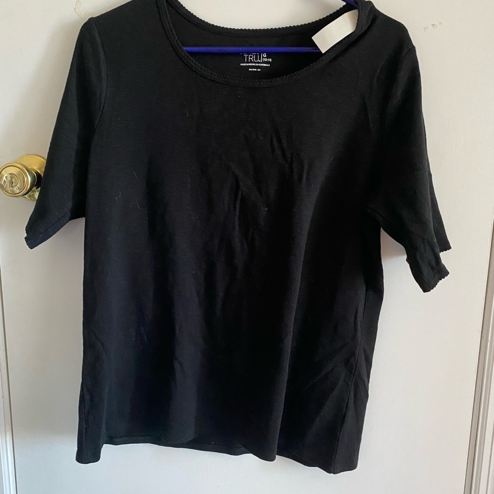 Black tee with ruffles at top and bottom of sleeve. New with tags